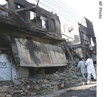 Shopkeepers visit their shops gutted by angry protesters, in the troubled city of Larkana, 29 Dec 2007